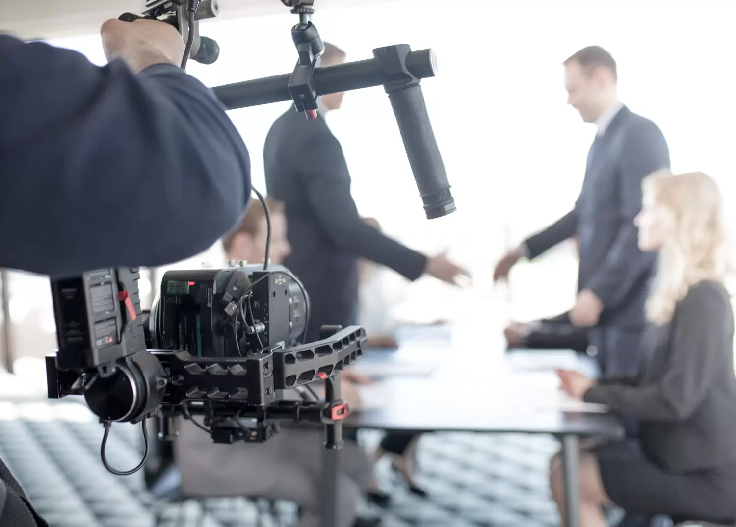 إنتاج الوسائط videographer using steadycam making video business people shaking hands